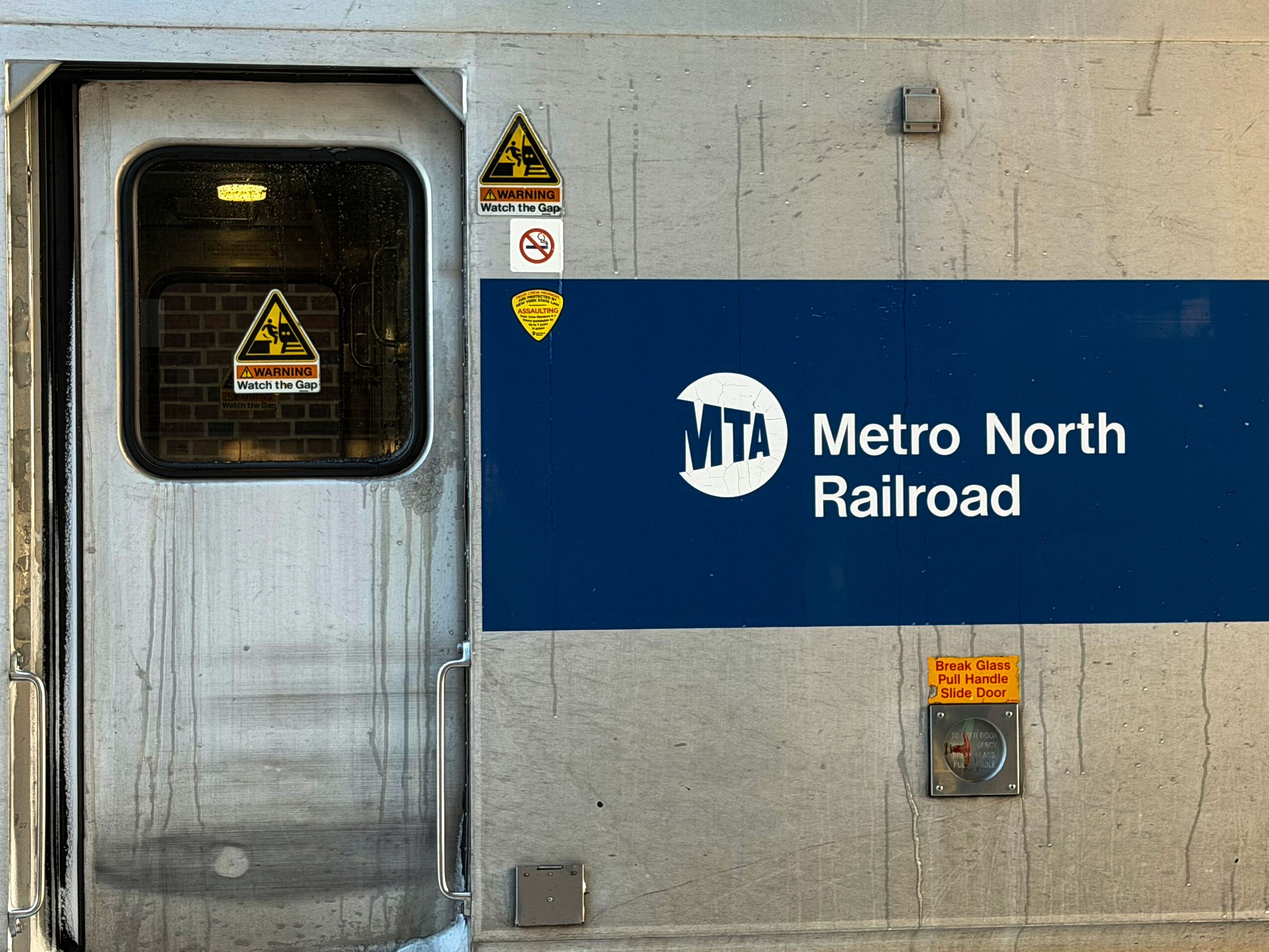 Detailed view of Metro North Railroad train door with safety signs