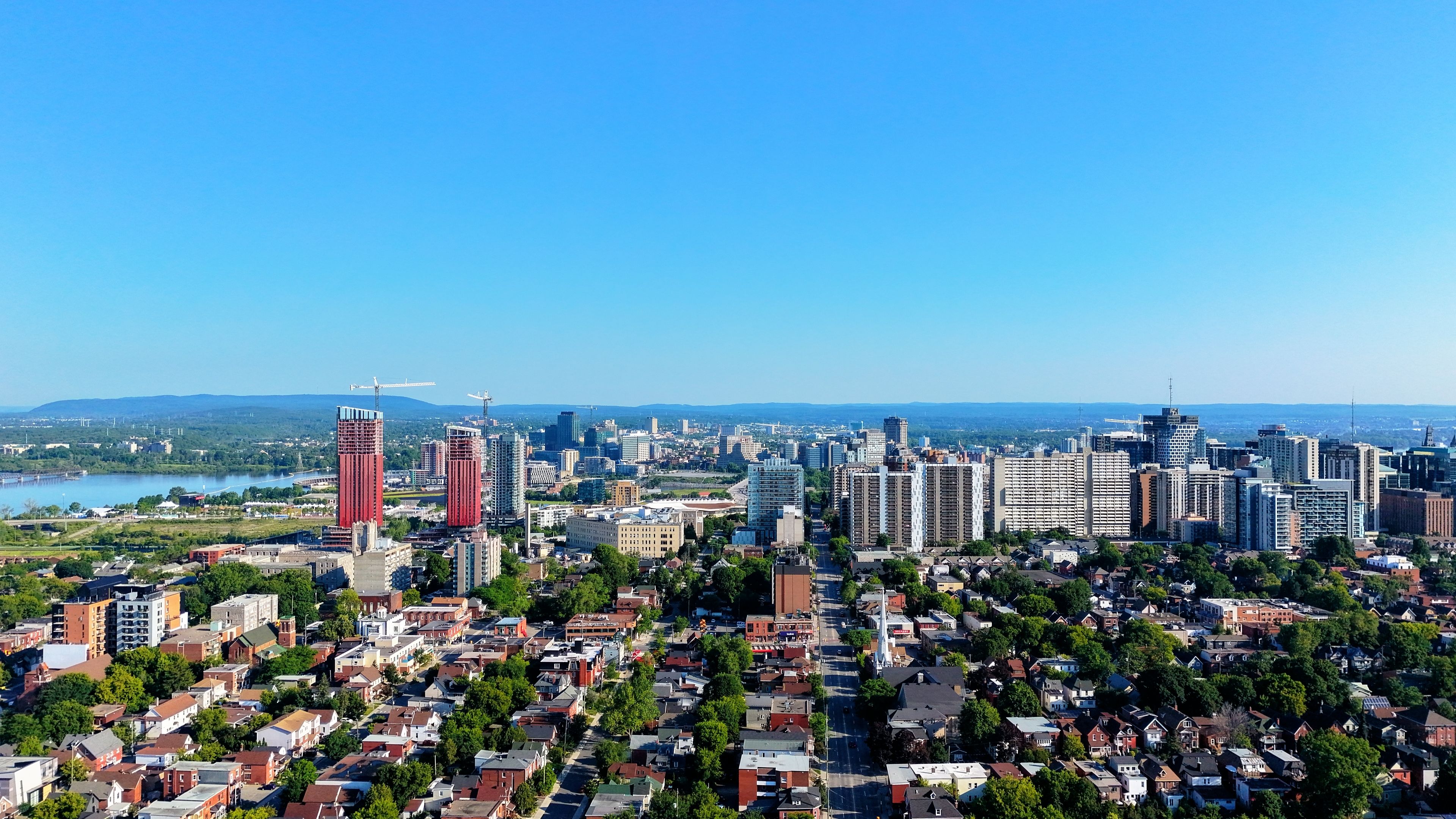 Aerial view of Montreal skyline with tall buildings and blue sky, showcasing urban architecture.