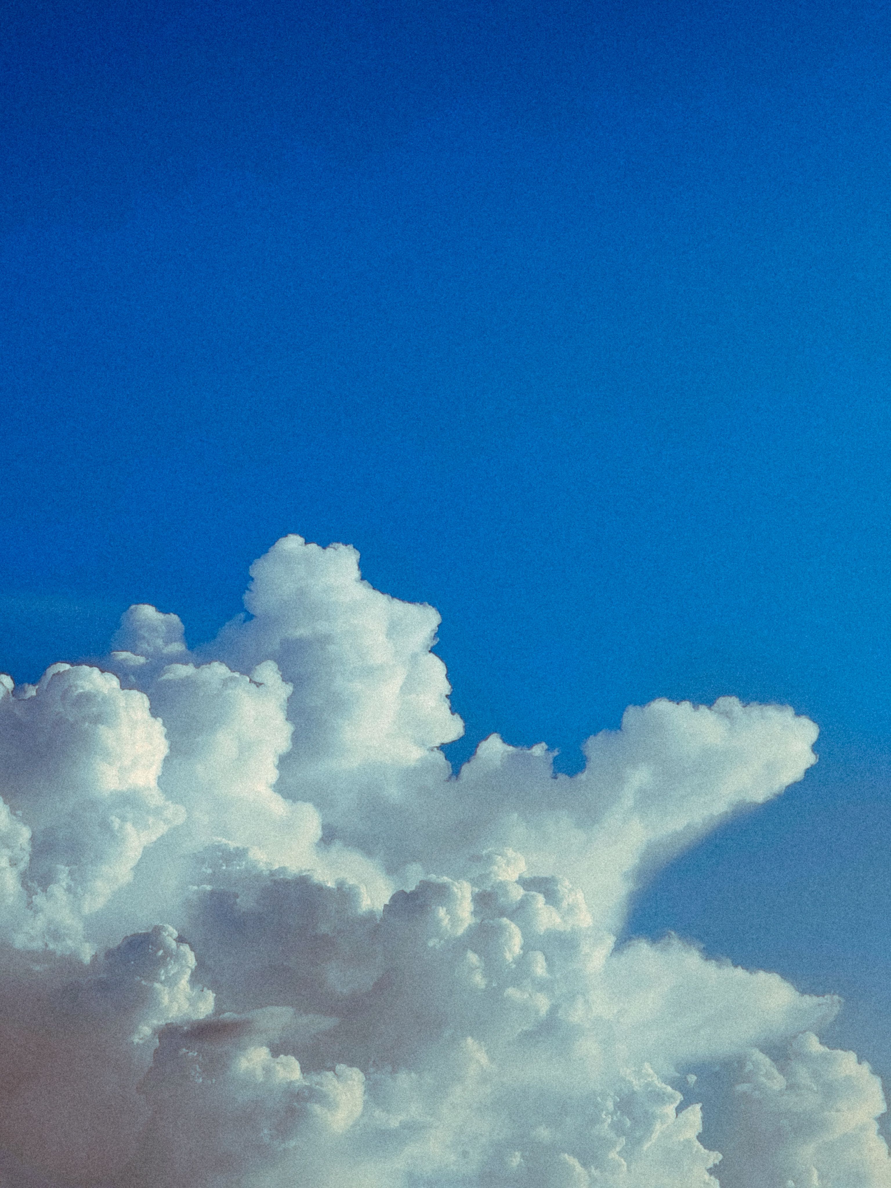 Vivid cumulus clouds contrast beautifully with a clear blue sky, capturing nature's dynamic beauty.