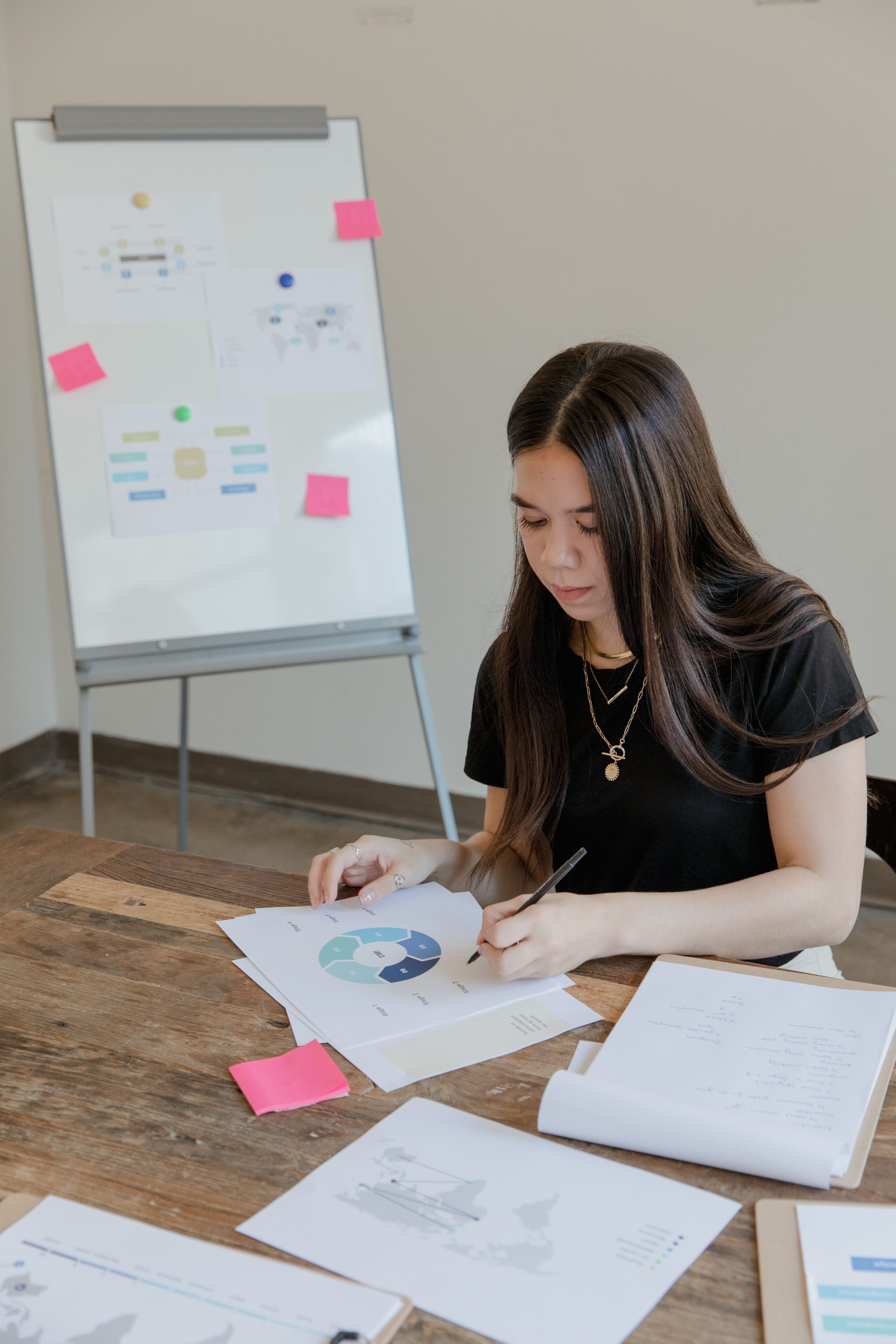 Businesswoman examines charts in a modern office setting, focusing on data analysis.